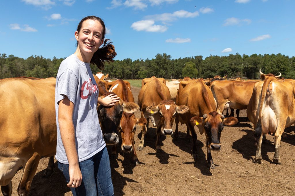 Adilaide Bates, Urban Studies Major with a Sustainable Urbanism Concentration ('21) and Sustainability Coordinator for CofC Dining Services gets up close and personal with the jearsey cows at Lowcountry Creamery.