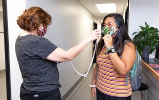 a student gets her temperature checked at student health services