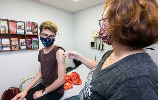 A student gets a shot in Student Health Services.