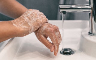 person washes their hands with soap and water
