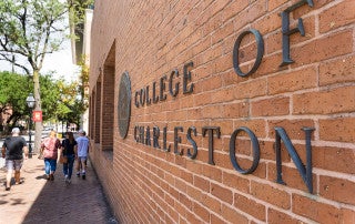 the words college of charleston on a brick wall on the campus