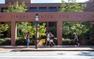 students walk along st. philip street on the college of charleston campus