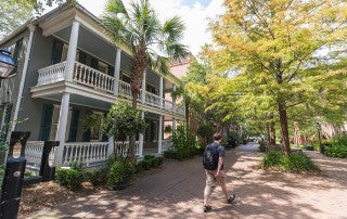 a student walks on the brick walkway of cougar mall at the college of charleston campus
