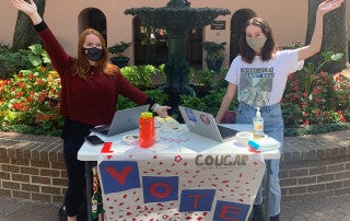 cougar votes members outside trying to register students to vote