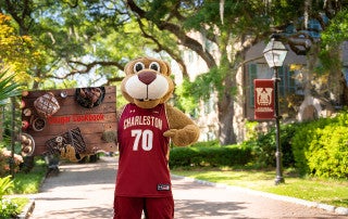 clyde the cougar holding a cougar cookbook