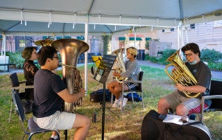 Brass musicians rehearse during a practice session in Barnet Courtyard.