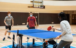 President Andrew Hsu and Dr. Rongrong Chen play ping pong with College of Charleston students at the Willard A. Silcox Physical Education and Health Center.
