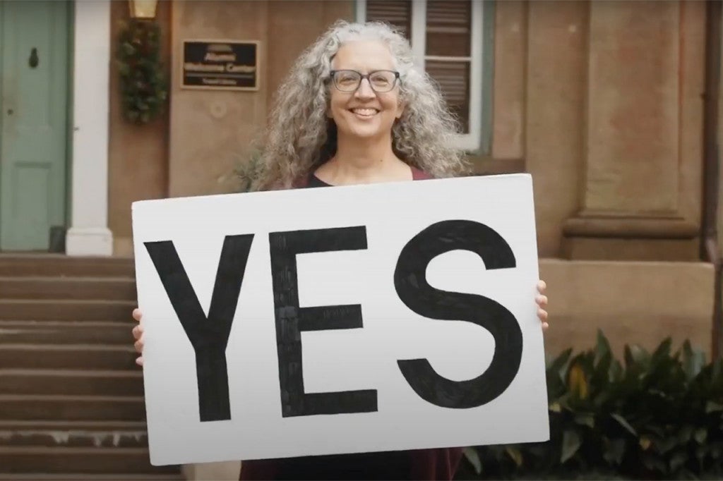 woman holds a sign that says yes
