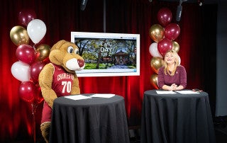 cofc alumna Lauren Arnott '13 and clyde the cougar during cofc day