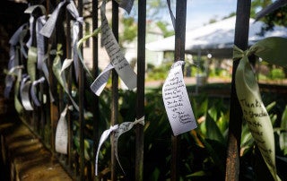 ribbons with messages tied to fence