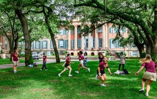 students run and play a game in the cistern yard at the college of charleston