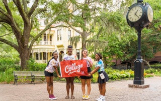 students hold a college of charleston sign