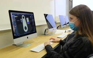 a systems engineering student works on a computer to design a project