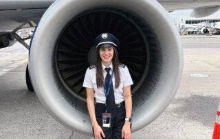 molllie warren stands by an airplane engine