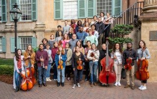 members of the cofc orchestra pose with their instruments