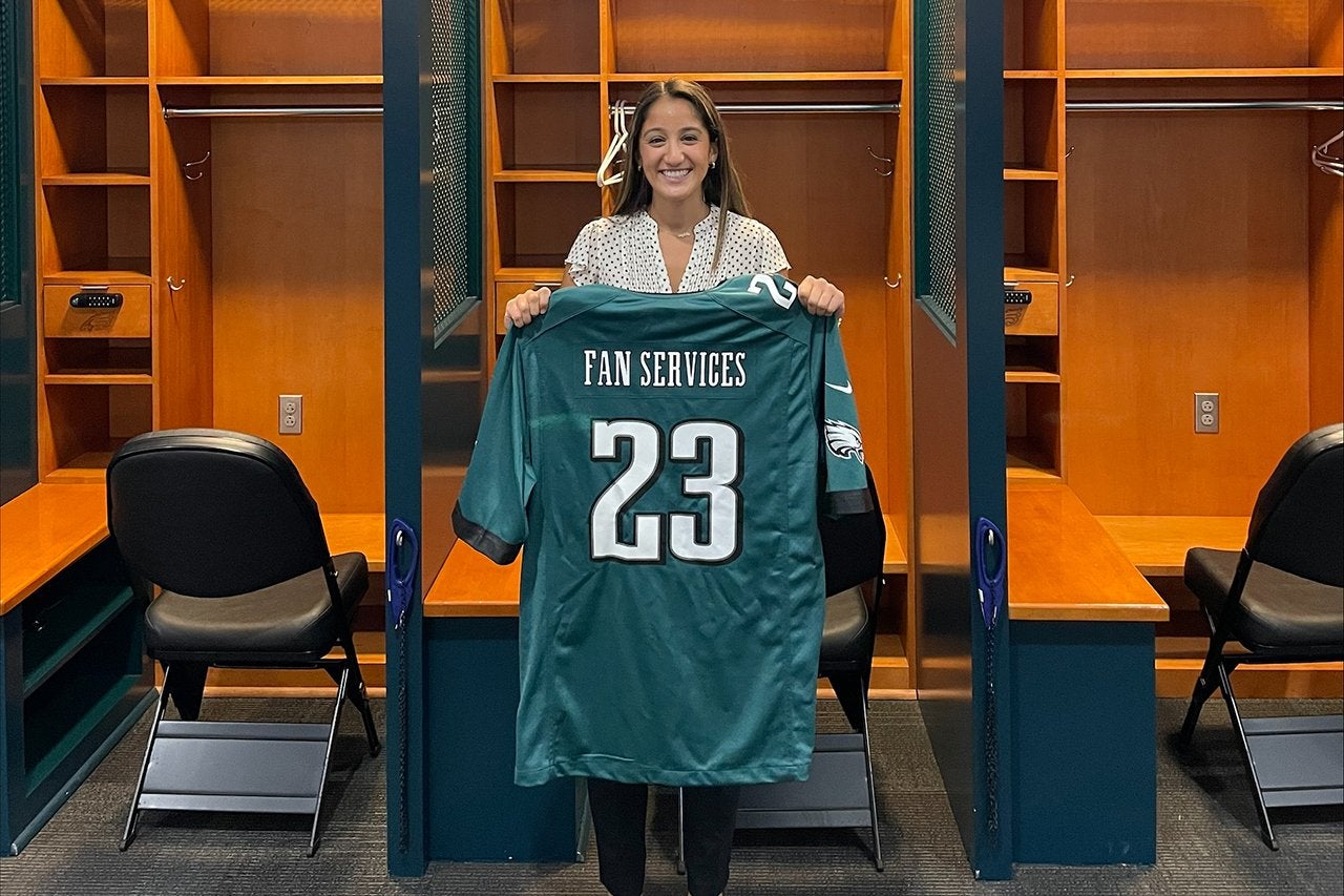 a woman holds a football jersey