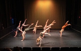 dancers swing their legs in unison at the Chapel Theatre