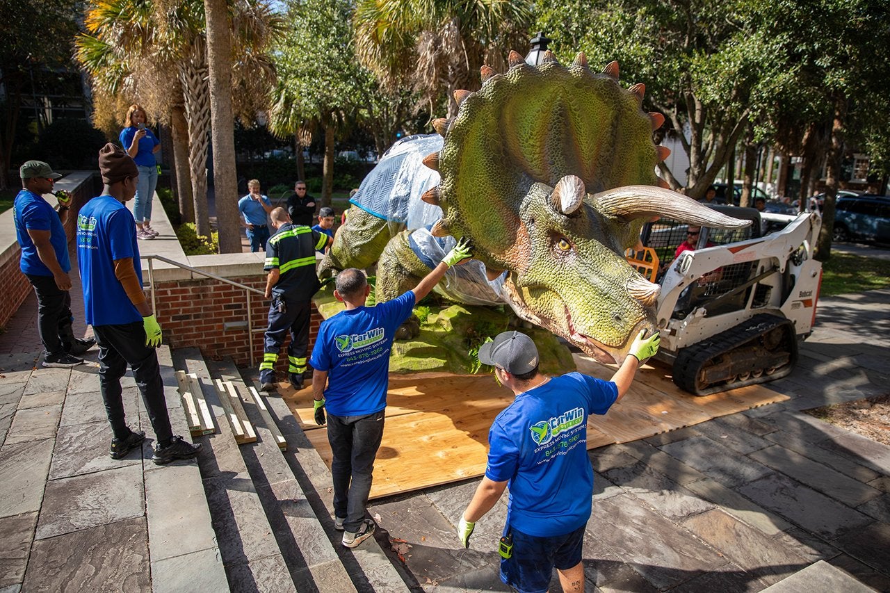 life sized dinosaurs are transported to campus