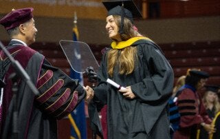 graduate student shakes hands with President Hsu