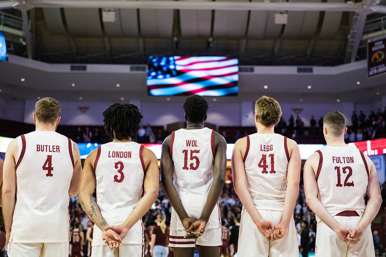 basketball players line up for the national anthem